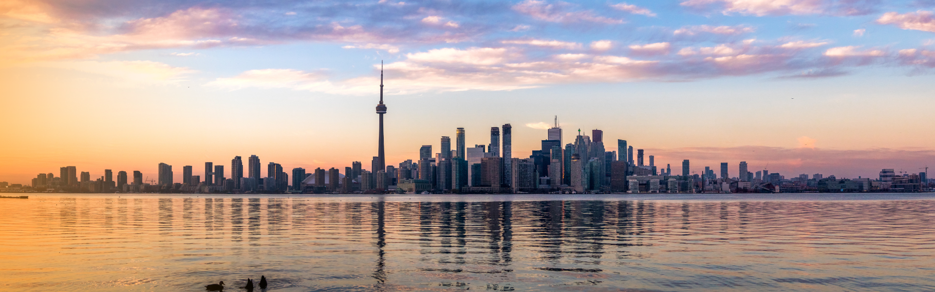 Toronto skyline at sunset reflecting on Lake Ontario, symbolizing Paramount Defense Group’s local presence